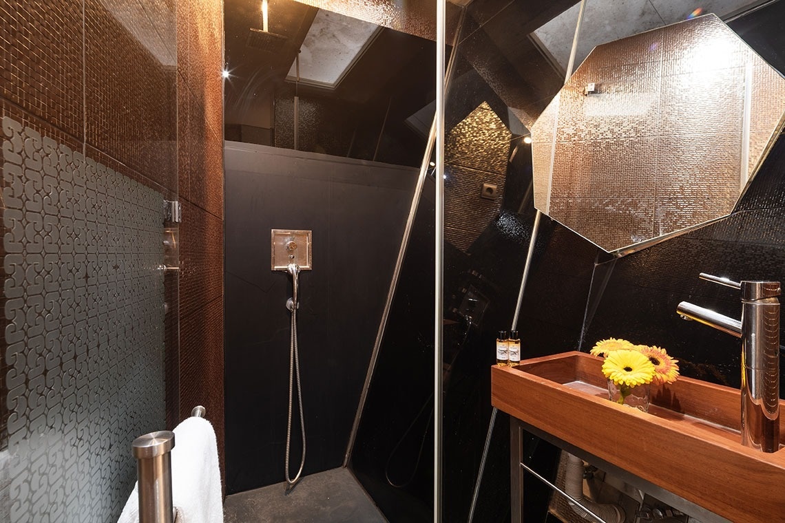 um banheiro com chuveiro e pia de madeira