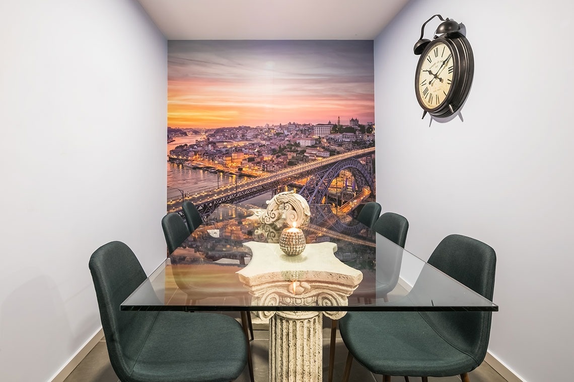 uma sala de jantar com uma mesa de vidro e cadeiras