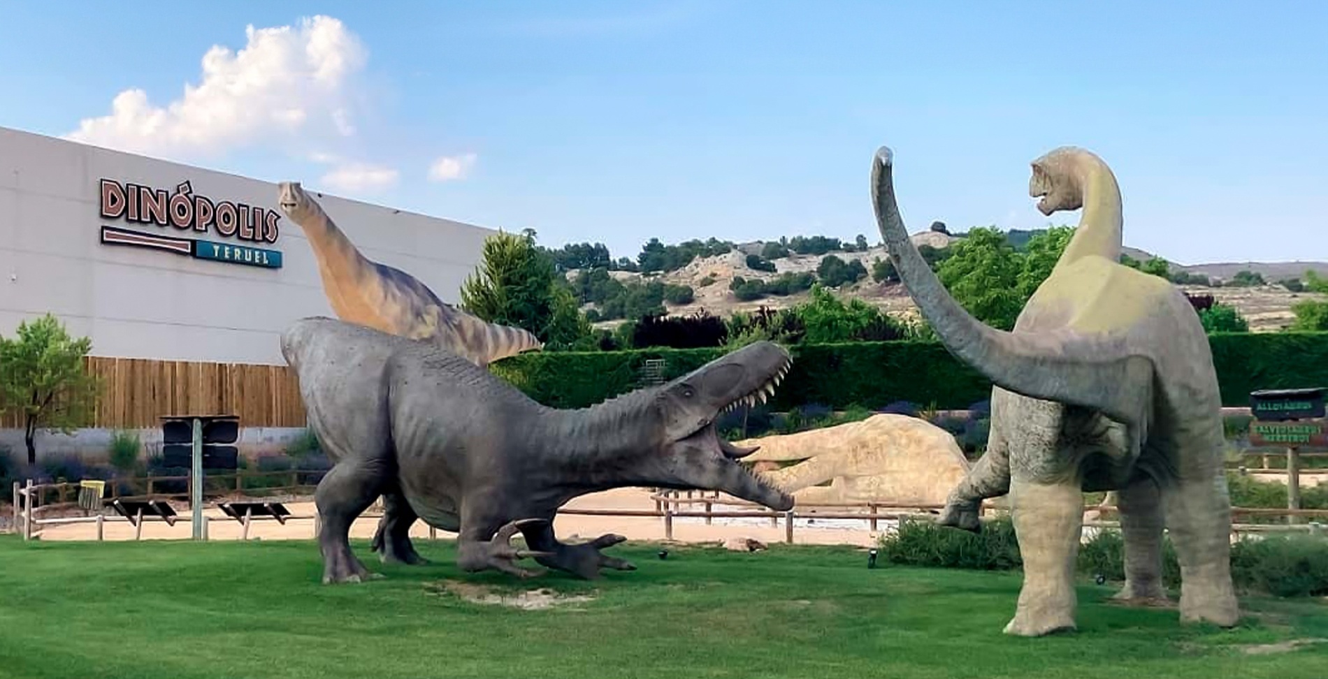 three dinosaurs are standing in front of a building that says dinopoly