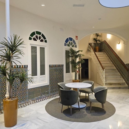 una sala de estar con una mesa y sillas y una escalera