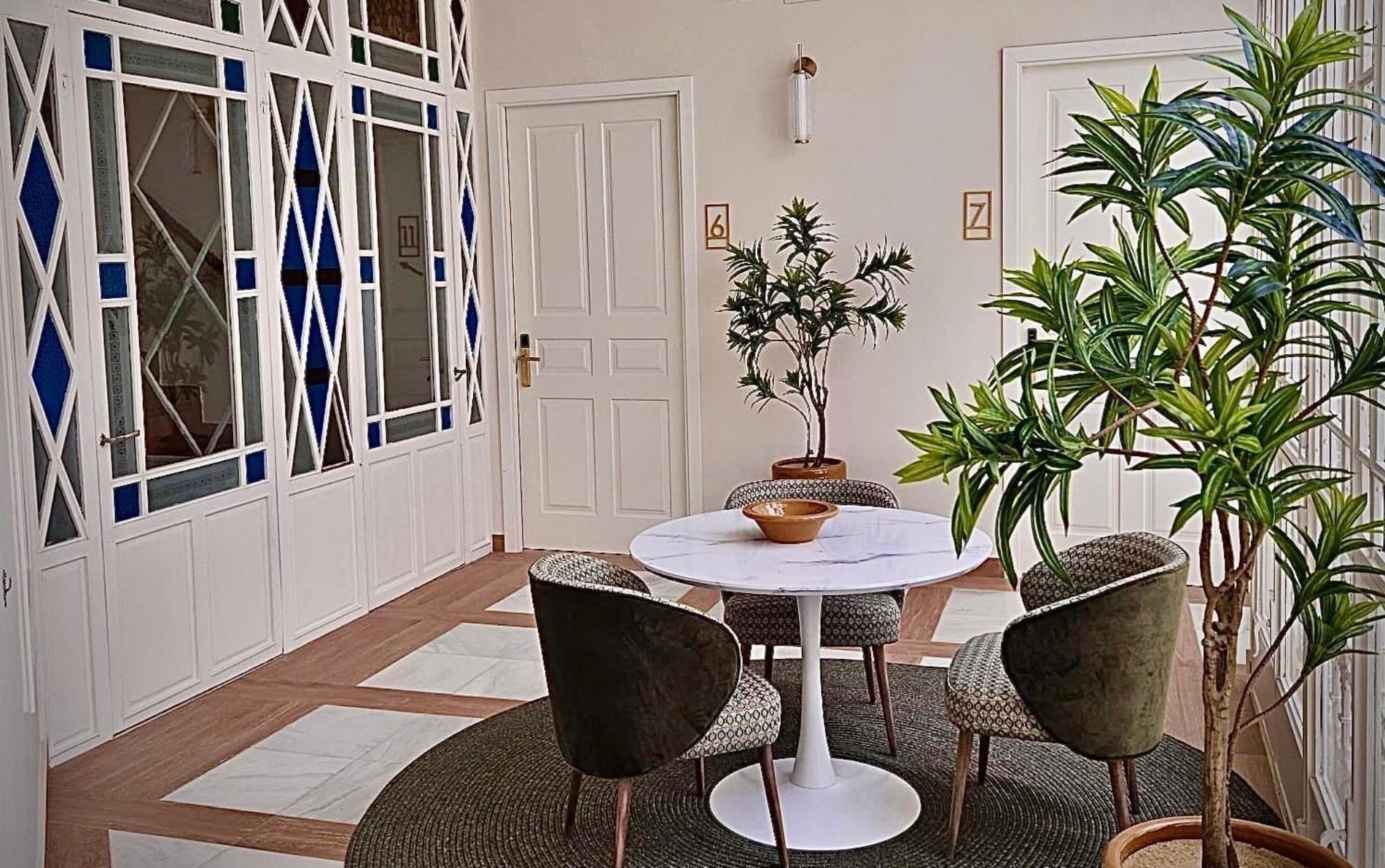 un patio lleno de muebles y plantas con la puerta a la izquierda