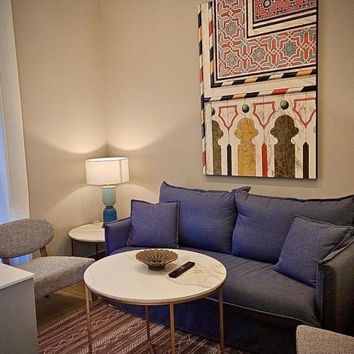 una sala de estar con un sofá azul y una mesa redonda