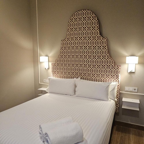 una habitación con una cama y una cabecera con un patrón geométrico