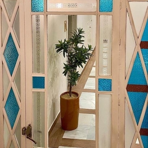 una planta en una maceta se sienta frente a una puerta de vidrieras