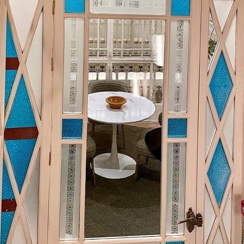 una puerta con vidrieras de colores y una mesa blanca