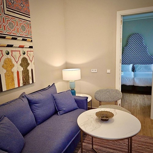 una sala de estar con un sofá azul y una mesa redonda