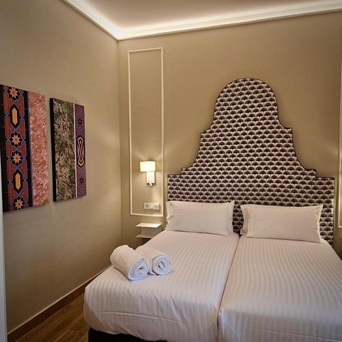 una habitación con dos camas y una cabecera con un patrón