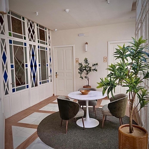 una sala de estar con una mesa y sillas y una planta