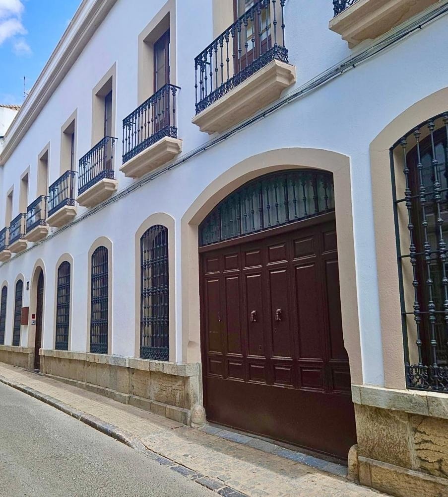 un edificio blanco con puertas marrones y balcones