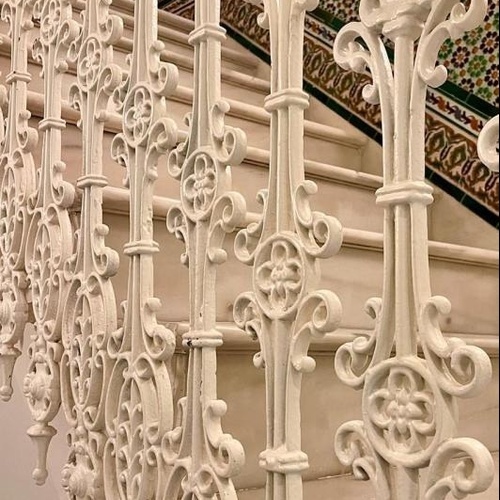 una escalera con una barandilla de hierro forjado blanco