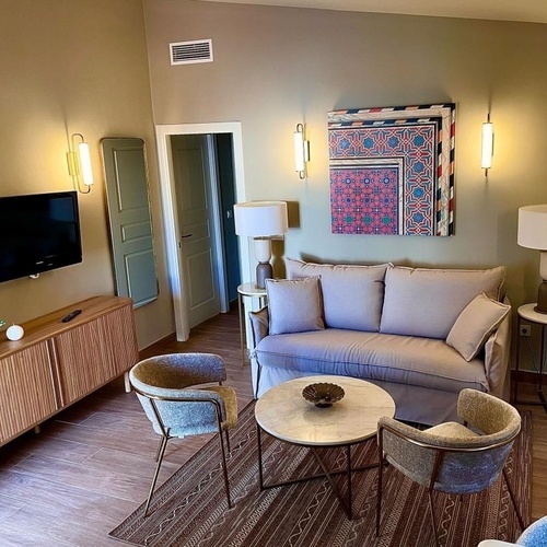 una sala de estar con un sofá y dos sillas