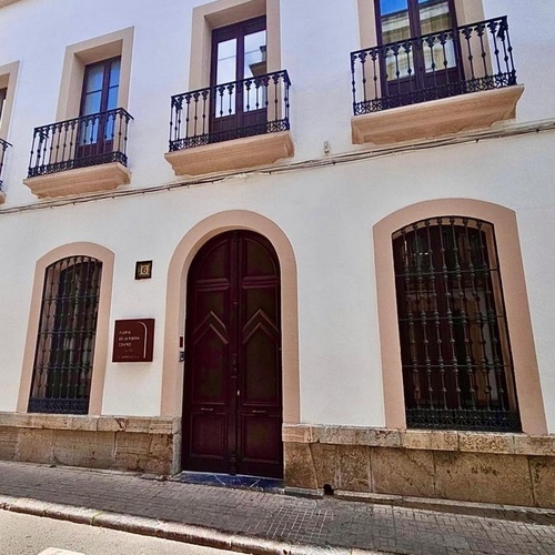 un edificio blanco con una puerta de madera marrón y un letrero que dice casa de la esperanza