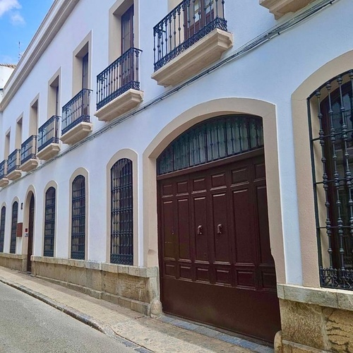 un edificio blanco con puertas marrones y balcones