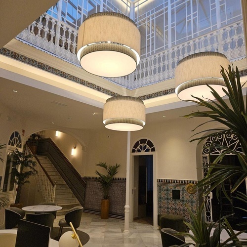 una habitación con una escalera y lámparas colgando del techo