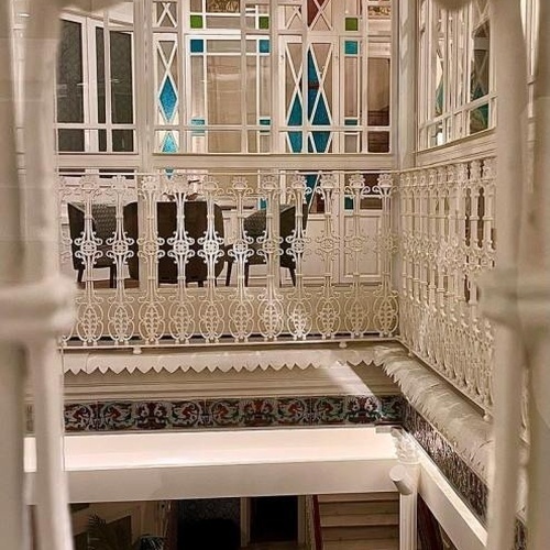 una vista de una escalera a través de una puerta de hierro forjado