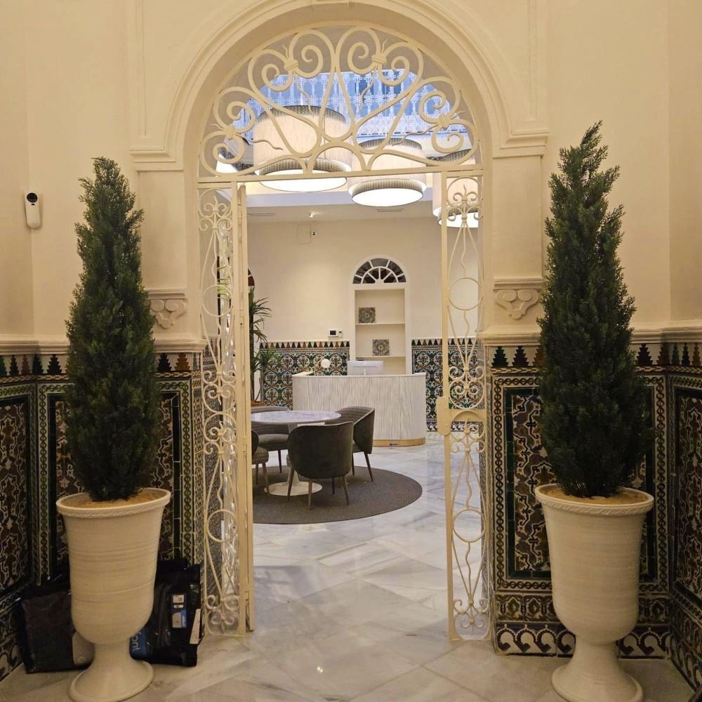 una puerta de hierro forjado conduce a una habitación con una mesa y sillas