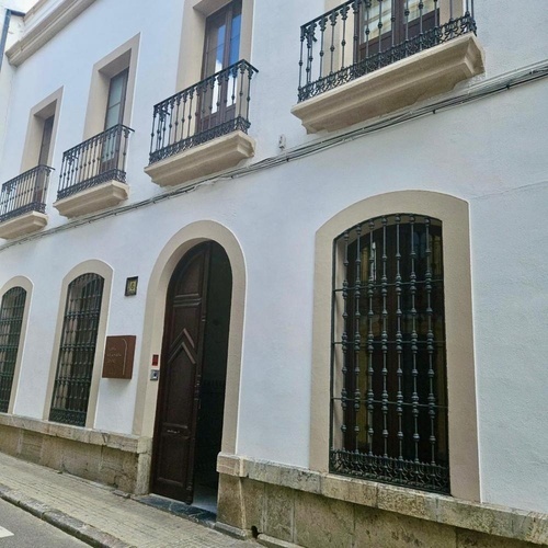 un edificio blanco con balcones y una puerta de madera