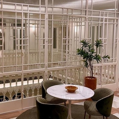 una sala de estar con una mesa y sillas y una planta