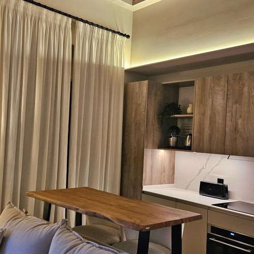 a kitchen with a wooden table and white curtains