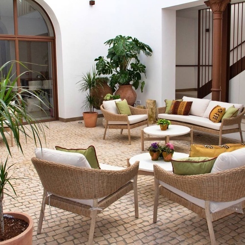 a courtyard with wicker furniture and potted plants