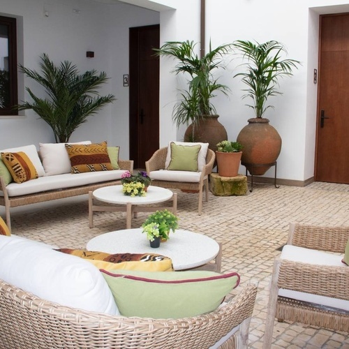 un patio con muebles de mimbre y plantas en macetas