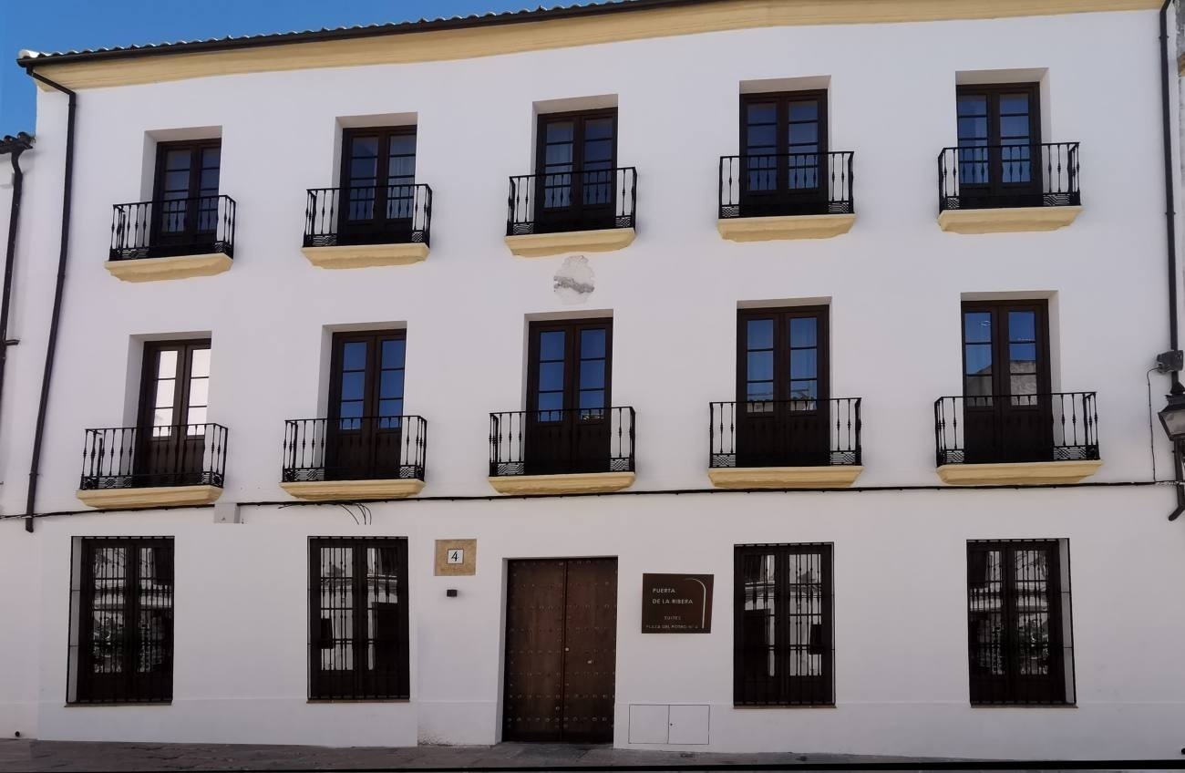 a white building with balconies has a sign on the door that says 