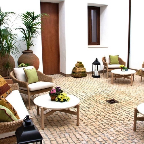 a courtyard with wicker furniture and a lantern