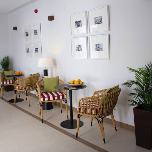 a hallway with wicker chairs and a table with a bowl of lemons on it