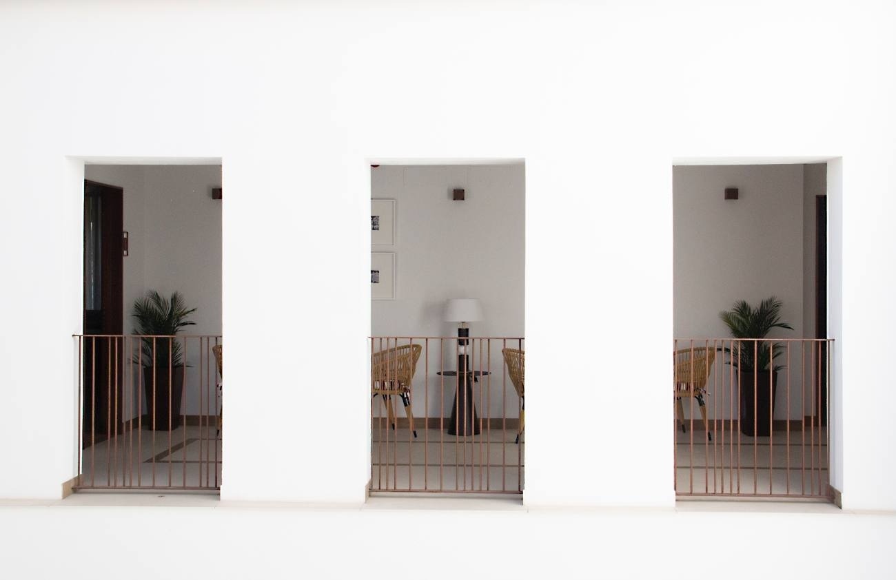 a balcony with a fence and a table and chairs