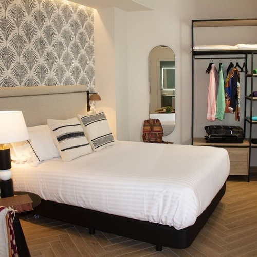 a bedroom with a large bed and a large mirror