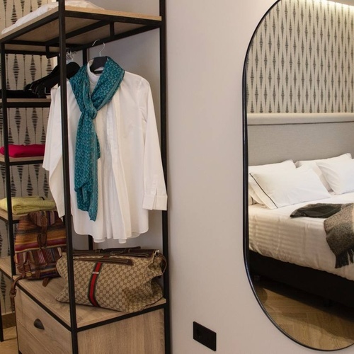 a bedroom with a closet and a mirror with a reflection of a bed