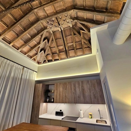 a kitchen with wooden cabinets and a wooden ceiling