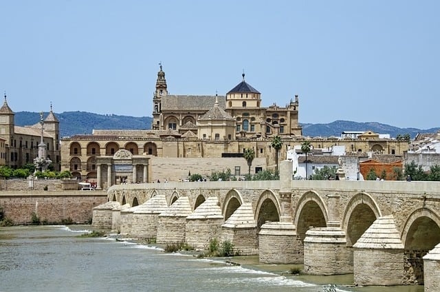 un pont sur une rivière avec une église en arrière-plan .