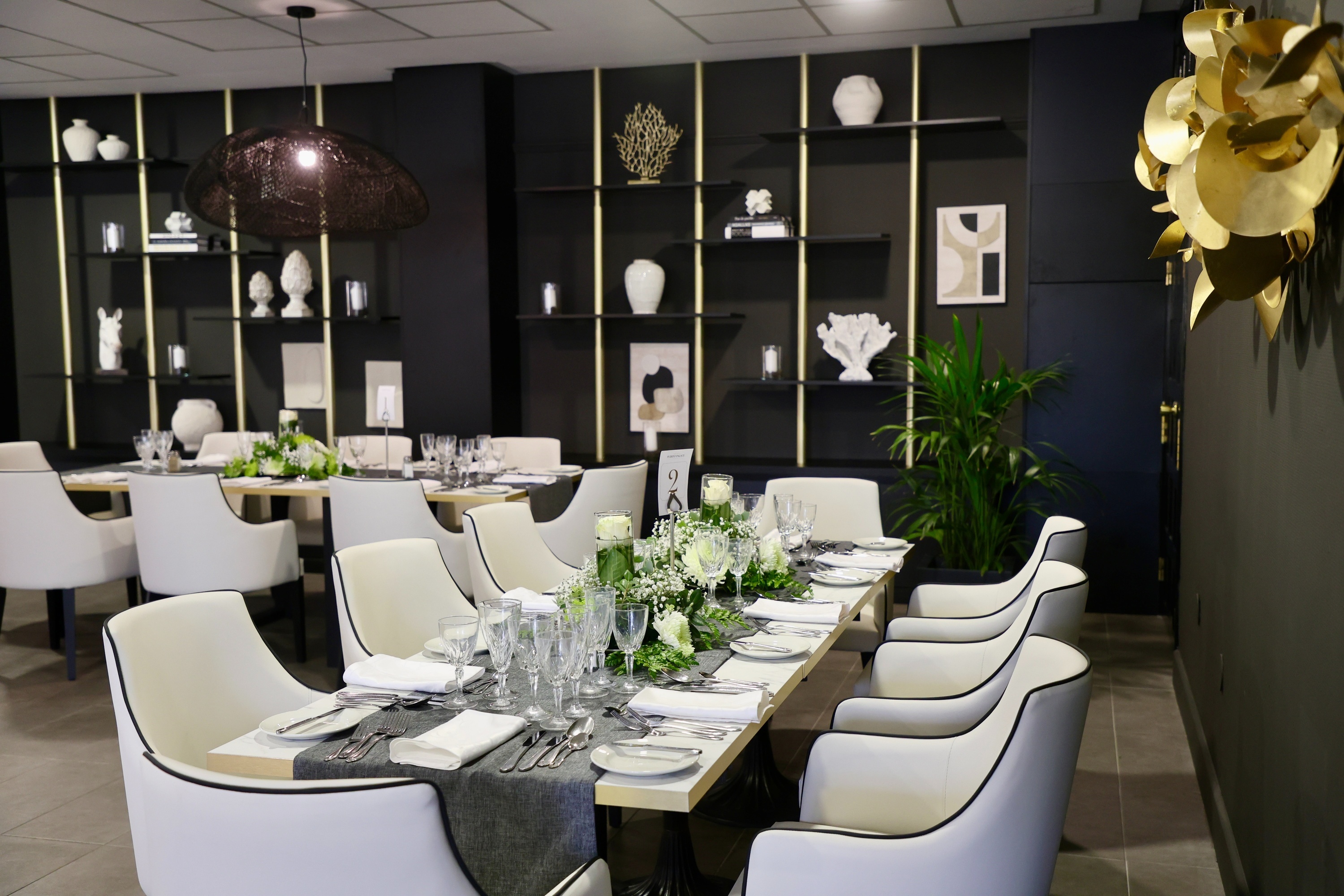 a dining room with a long table and white chairs