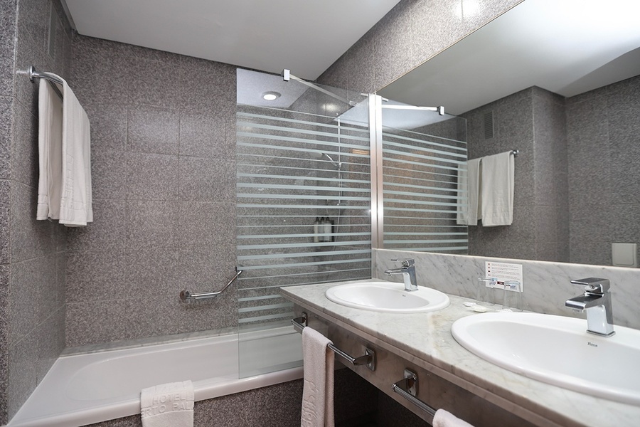 un baño con dos lavabos y una bañera