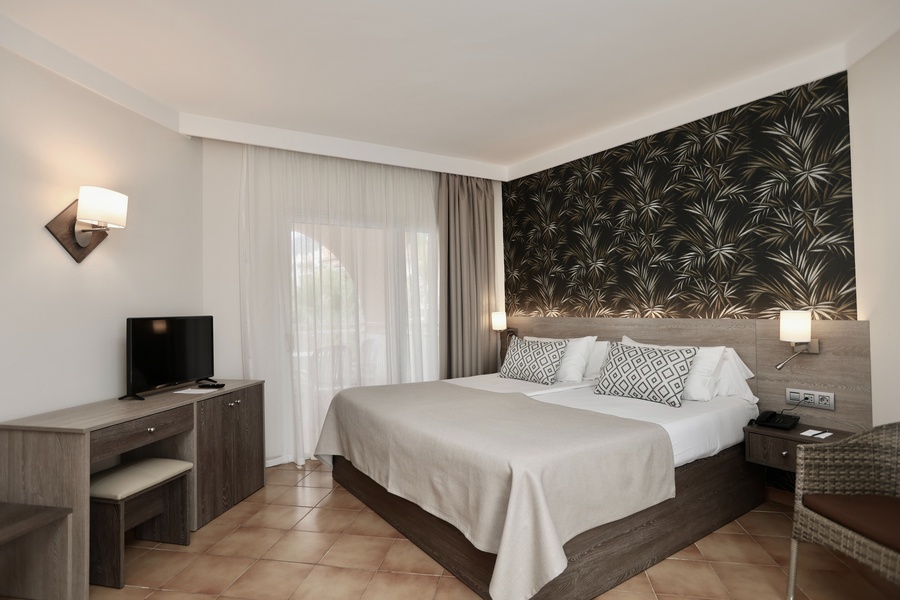 una habitación de hotel con una cama y una televisión