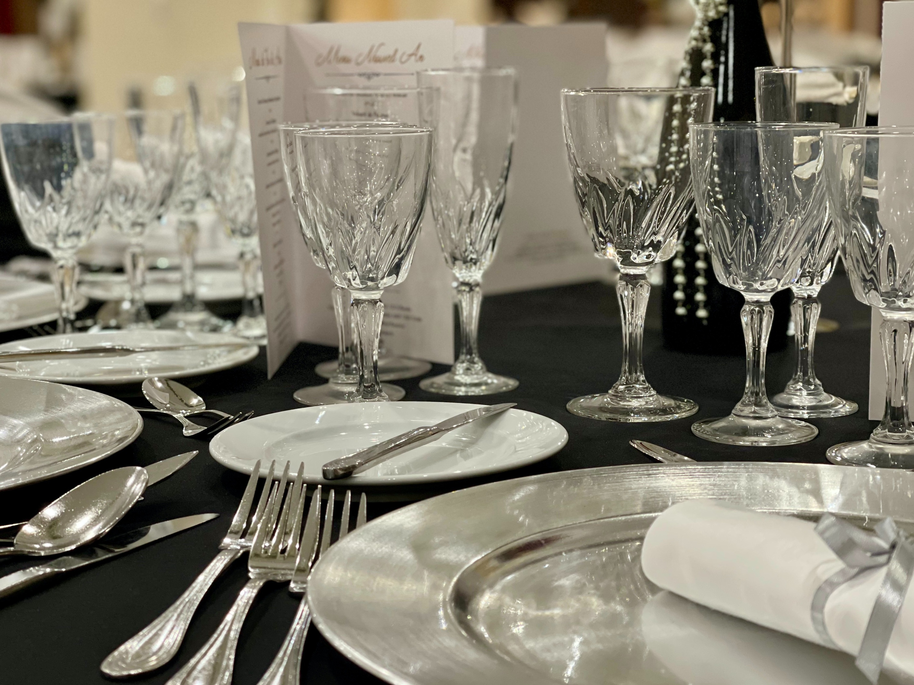 une table avec des assiettes et des verres et un menu à côté