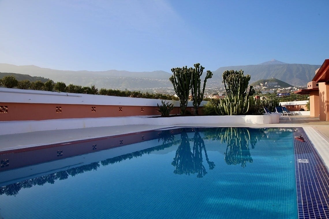 a large swimming pool with mountains in the background
