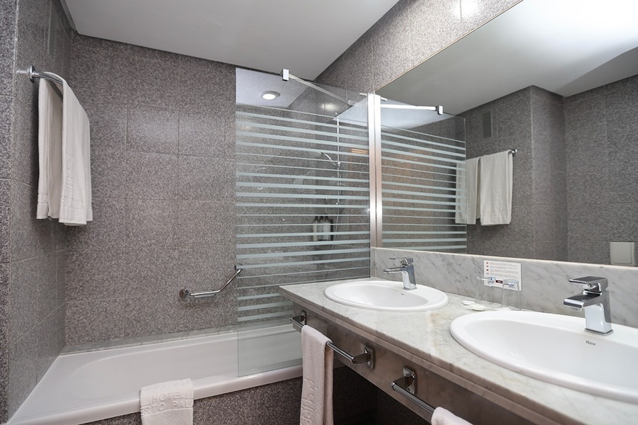 un baño con dos lavabos y una bañera