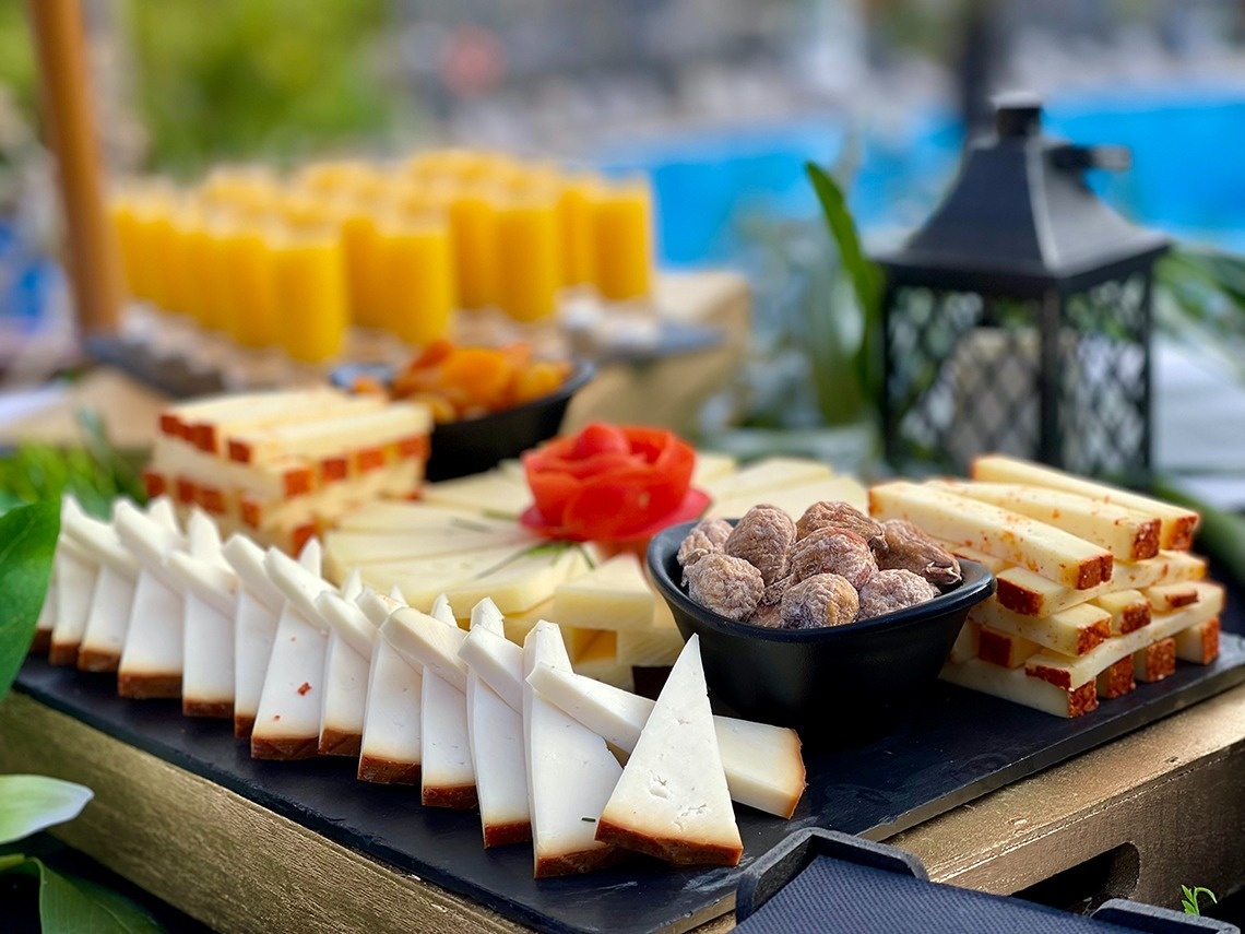 a variety of cheeses and nuts on a cutting board