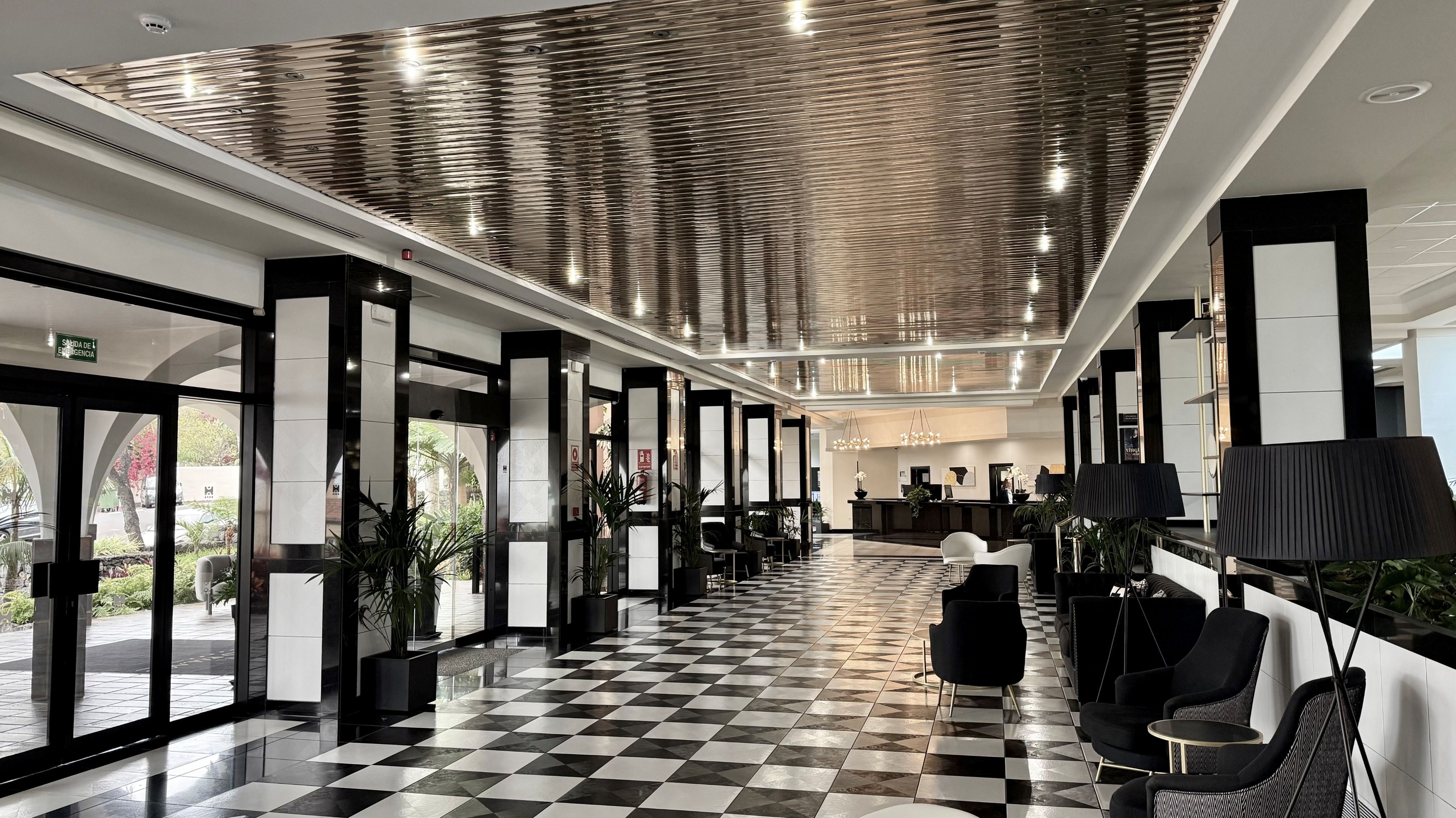 a hotel lobby with a checkered floor and a silver ceiling