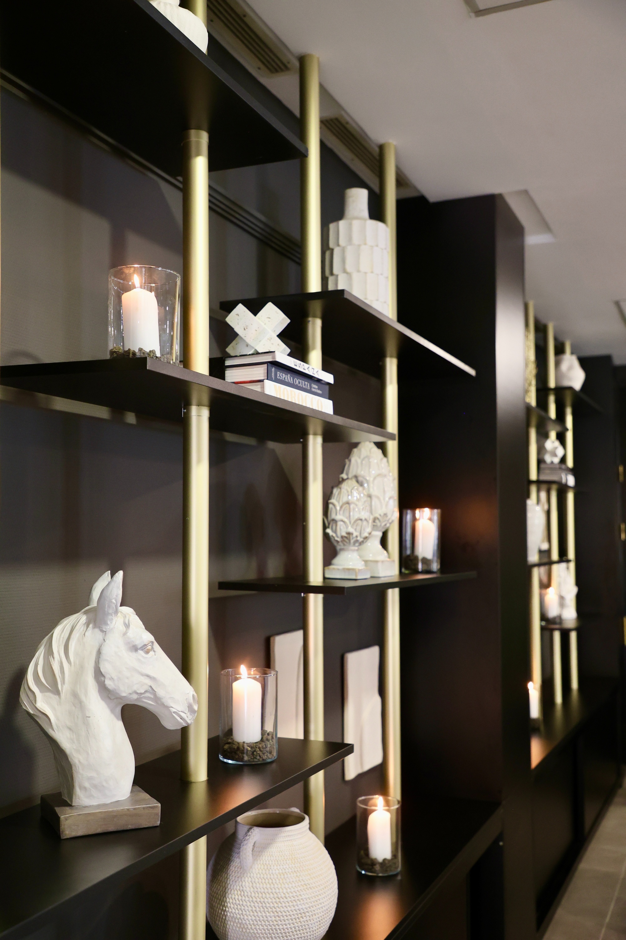 a book on a shelf with a horse head and candles