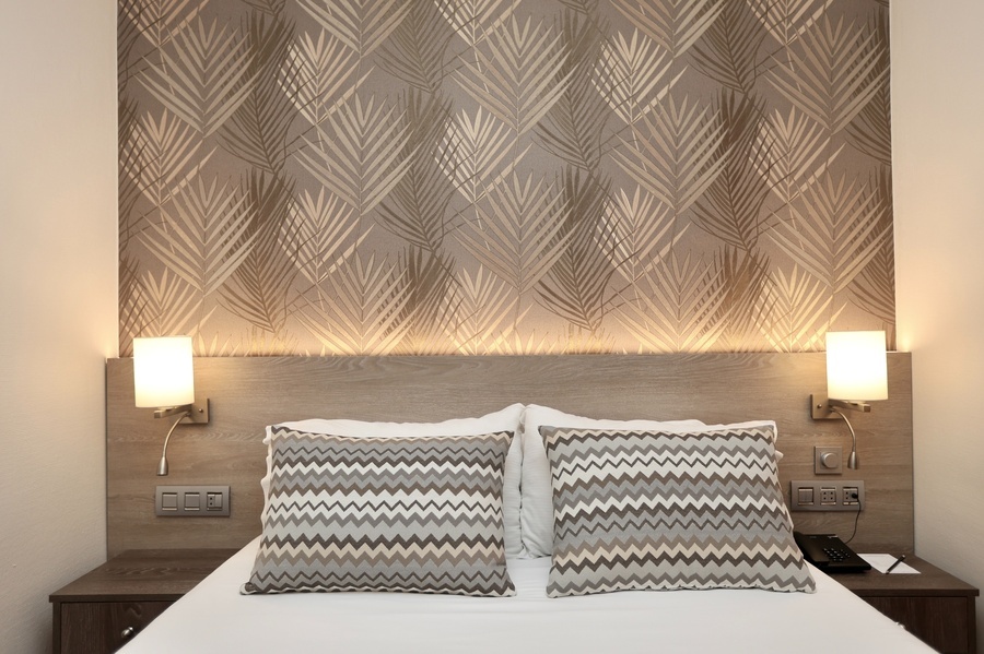 una habitación de hotel con una cama y dos lámparas