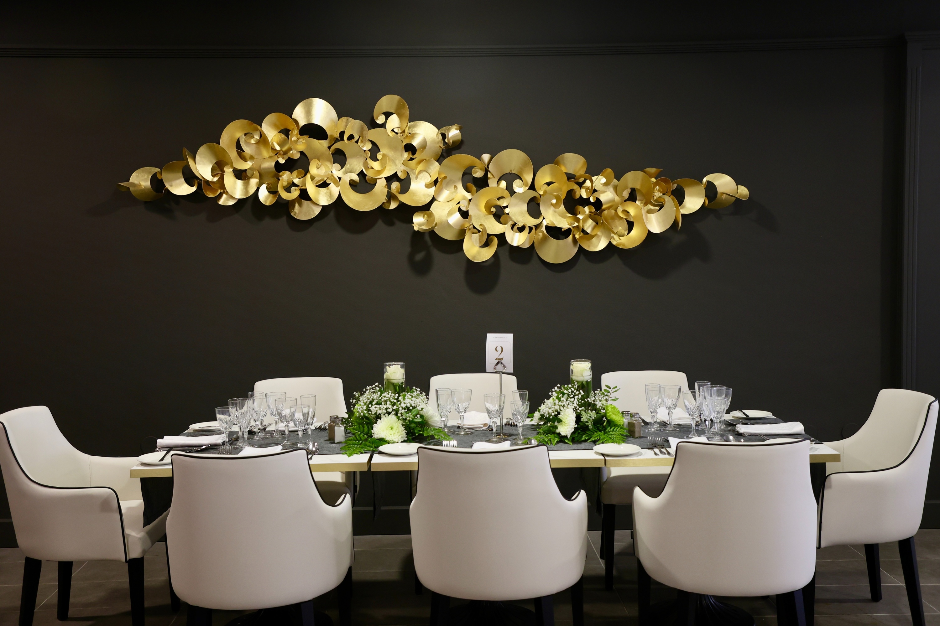 a dining room table with white chairs and a sign that says ' a ' on it