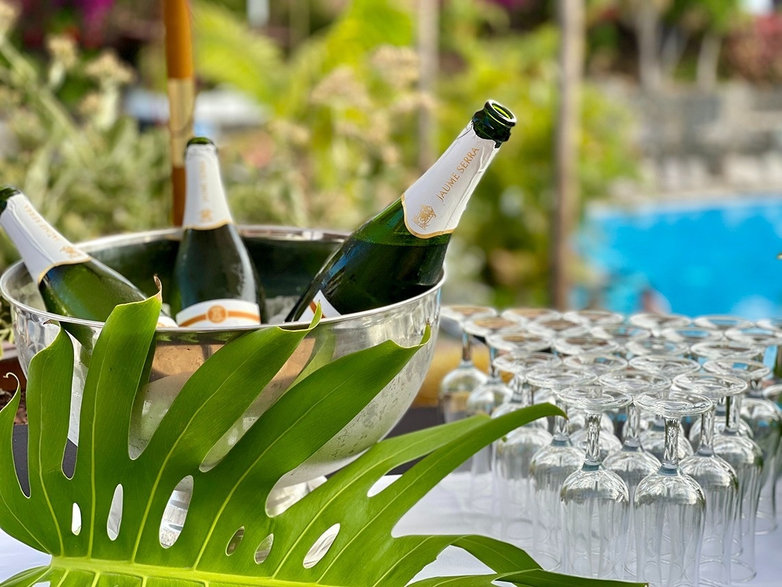 a bride and groom sit at a table with two drinks on it