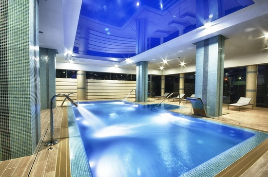 a large indoor swimming pool with a blue ceiling
