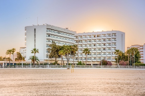 un gran edificio blanco con muchos balcones está en la playa