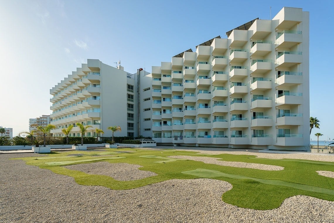 un gran edificio blanco con muchos balcones y un campo de golf