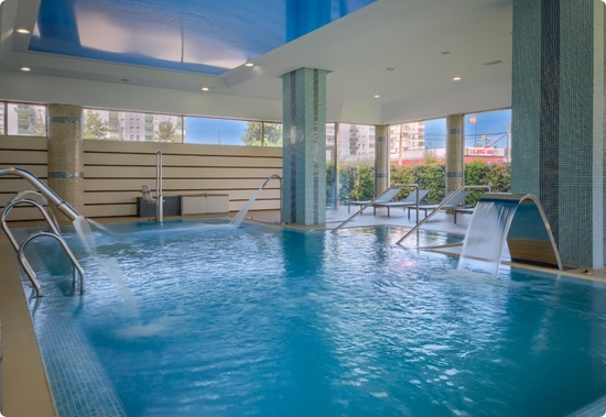 a large indoor swimming pool with a blue ceiling