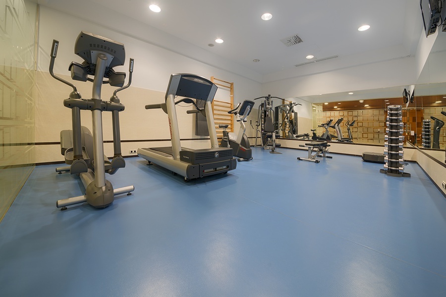 a gym with a treadmill and an elliptical